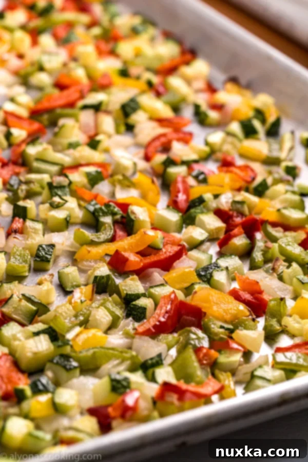 Colorful roasted vegetables ready to be added to dishes, showcasing a mix of bell peppers, zucchini, and onions