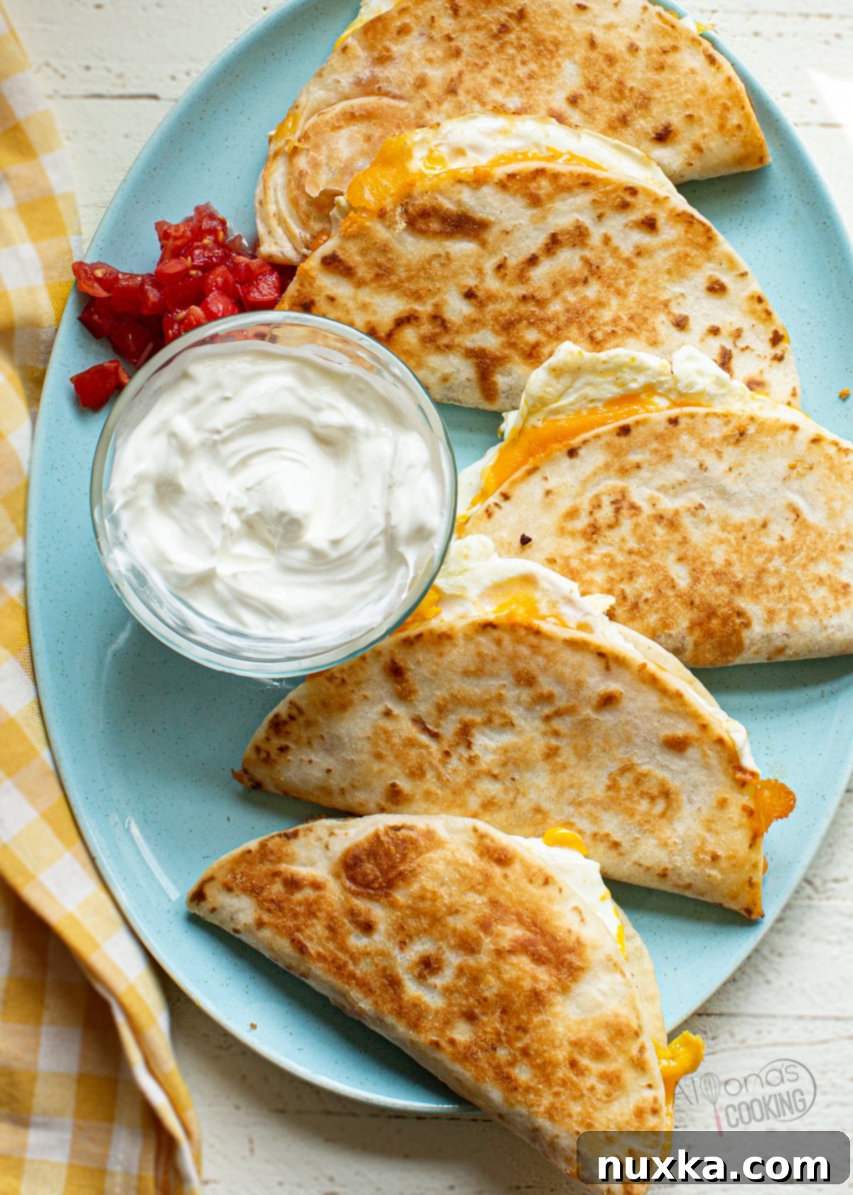 Crispy breakfast quesadillas with egg, cheese, and bacon on a blue plate, ready to be served