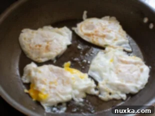 How to fry eggs in a pan for breakfast quesadillas, cooking until desired doneness.