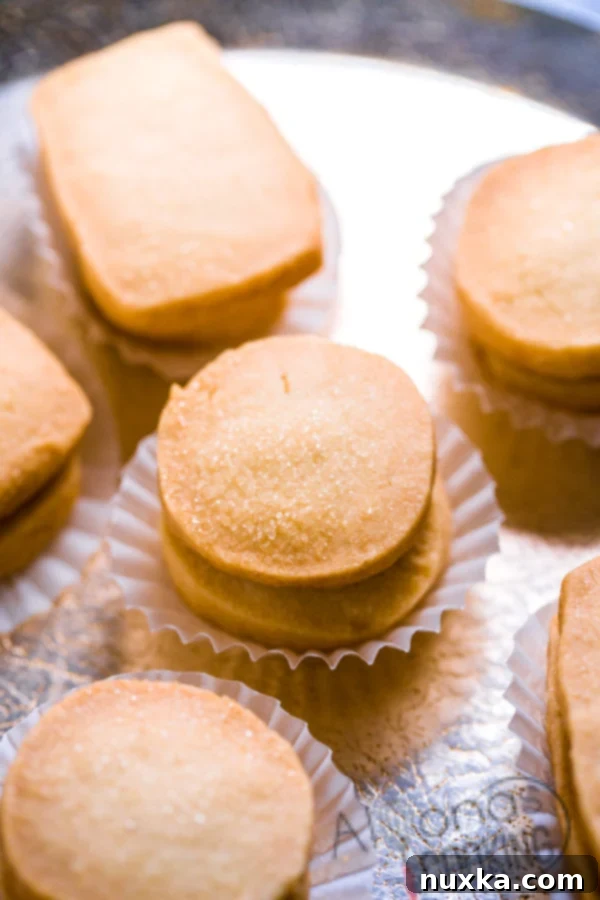 Golden, crunchy 3-ingredient butter cookies piled on a plate, reminiscent of classic Danish cookie tins, invitingly delicious.