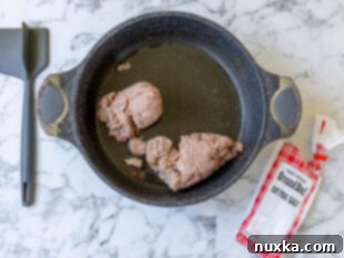 browning ground beef with water to avoid oil splatters and make crumbled meat easier