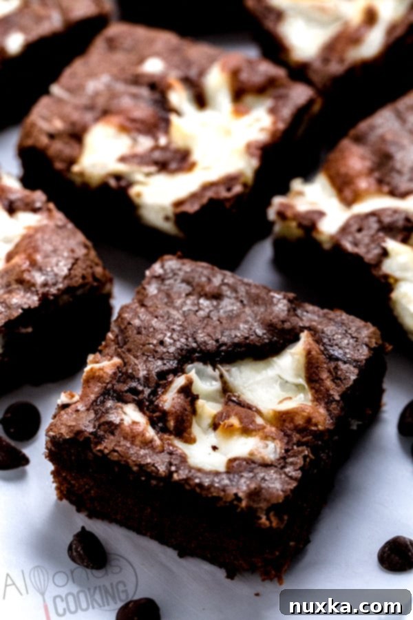 Fudgy cream cheese brownies with a beautiful cheesecake swirl, cut into perfect squares