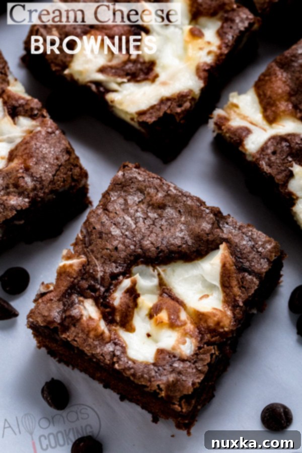 A stack of perfectly cut cream cheese brownies on a serving plate, inviting a bite