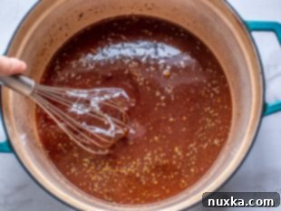 Ribs being placed into a Dutch oven with BBQ sauce, ready for braising in the oven