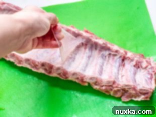 Pork ribs sliced into individual portions, coated in BBQ sauce before braising