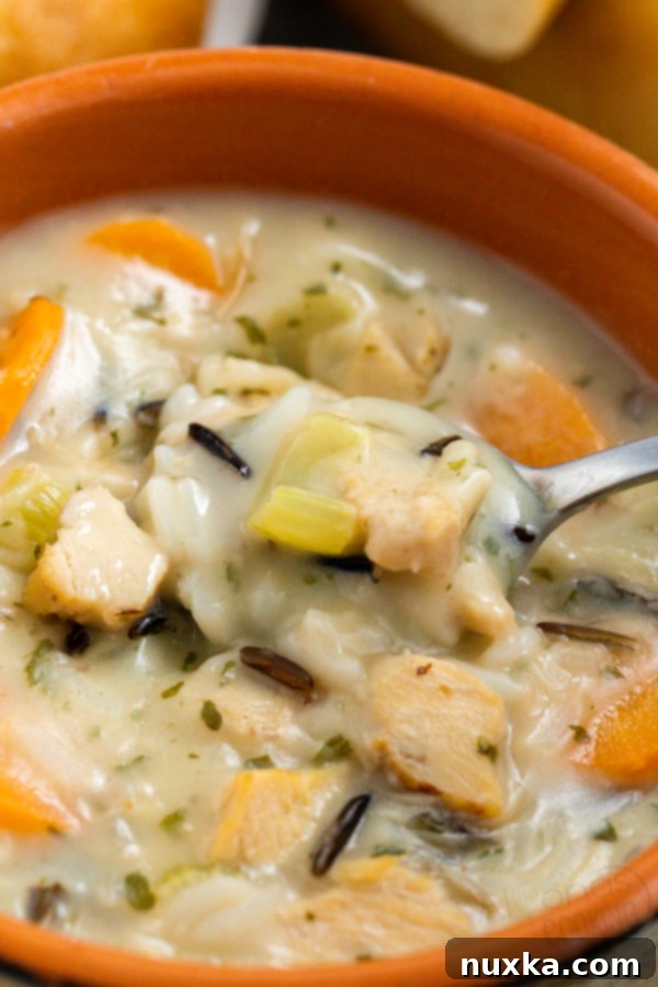 Another view of a serving of creamy chicken and wild rice soup with fresh parsley garnish