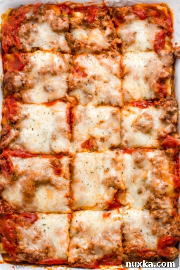 Top view of a golden-brown lasagna casserole, richly layered with melted cheese and savory meat sauce, garnished with fresh parsley.
