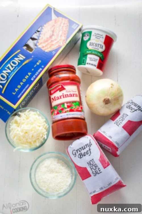 Ingredients laid out for a classic lasagna recipe, including ground beef, onion, marinara sauce, and a three-cheese blend, neatly arranged on a wooden surface.