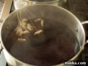 Sugar being whisked into hot tea concentrate until fully dissolved.