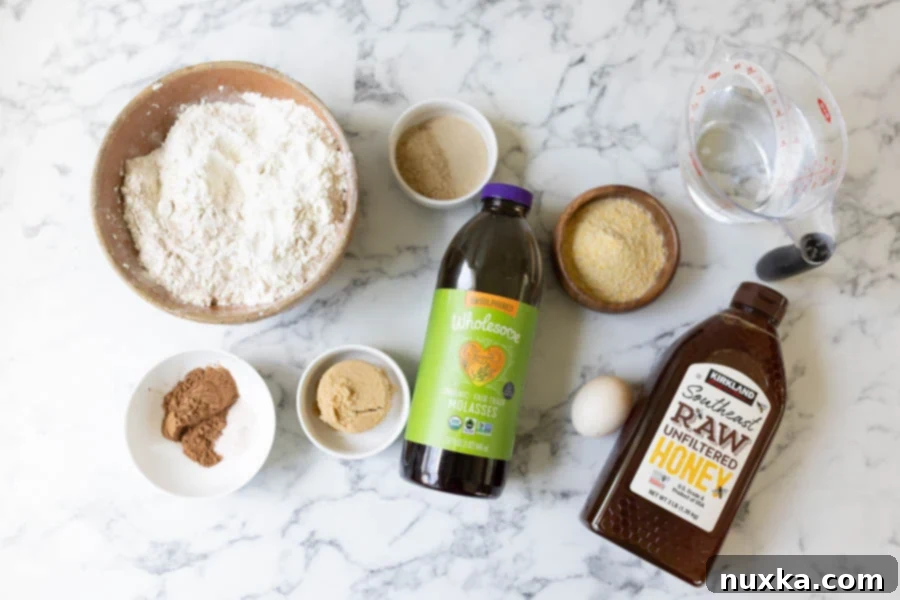 All ingredients for Outback bread (whole wheat flour, bread flour, brown sugar, blackstrap, molasses, cocoa powder, salt, dry active yeast, water, granulated sugar, honey, egg, and cornmeal).