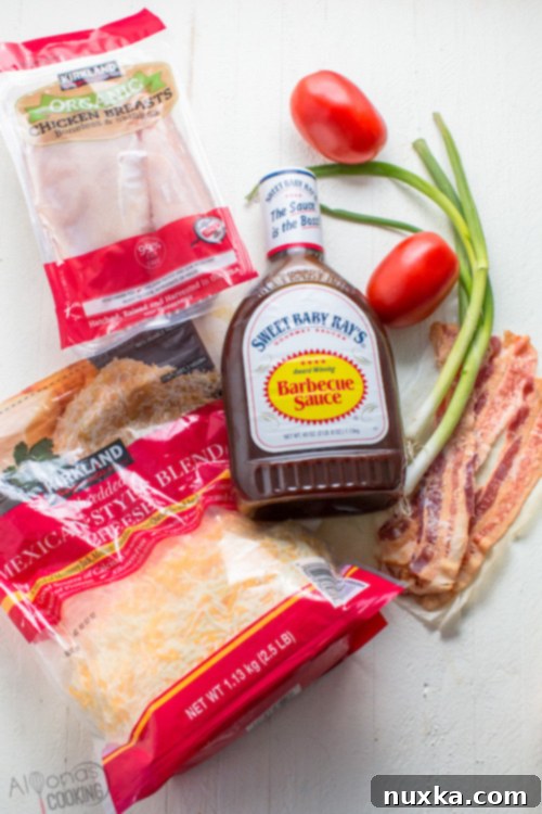 ingredients for cheesy bacon bbq chicken breasts recipe: boneless chicken breast, seasonings for the chicken rub, oil, creamy bbq sauce, cooked bacon slices, freshly diced tomatoes, and green onions. 