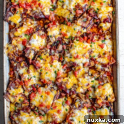 Loaded Monterey BBQ Chicken with Cheesy Bacon 2 cheesy bacon BBQ chicken on a baking sheet baked from the oven. This Monterey chicken is a Chilis inspired dish topped with bbq sauce, bacon, Monterey Jack cheese, and tomatoes
