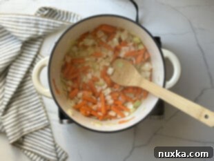 Step 3: Sautéing carrots and onions, then adding beef and spices.