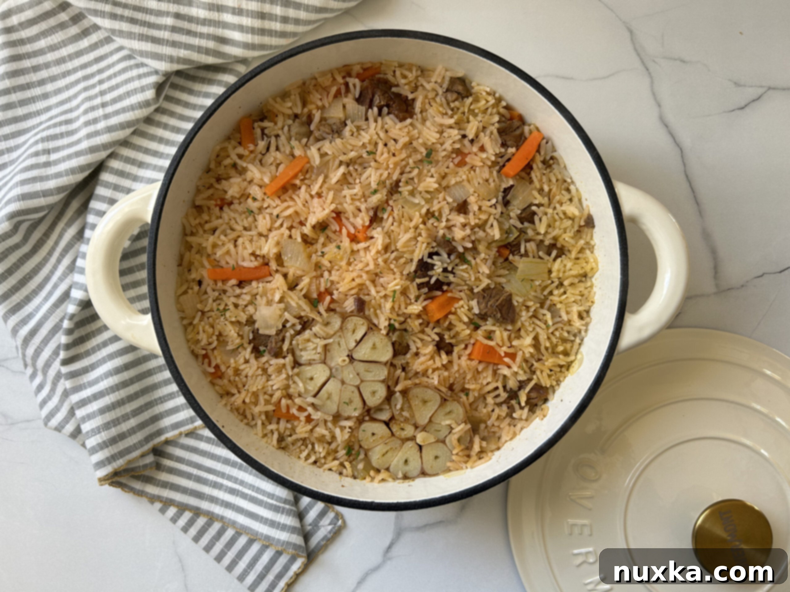 Ukrainian Beef Plov served in a white cast-iron Dutch oven, garnished with fresh herbs.
