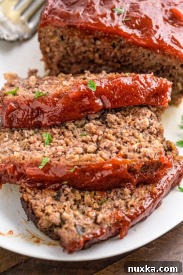 Glazed meatloaf ready to be sliced, showcasing its rich brown sugar and ketchup topping