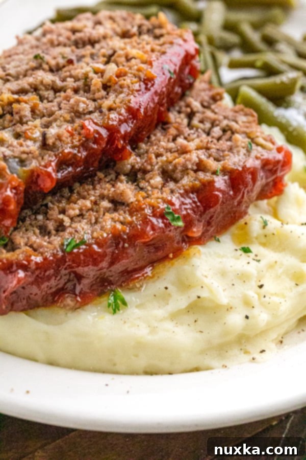 Slices of classic meatloaf with a rich, glossy glaze, ready to serve with sides.