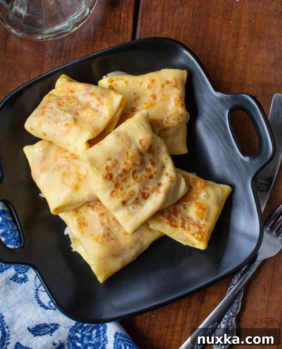 Delicious savory crepes filled with a hearty chicken and bell pepper mixture, garnished with fresh dill and sour cream sauce.