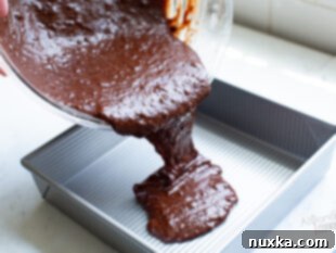 Pouring brownie batter into a pan.
