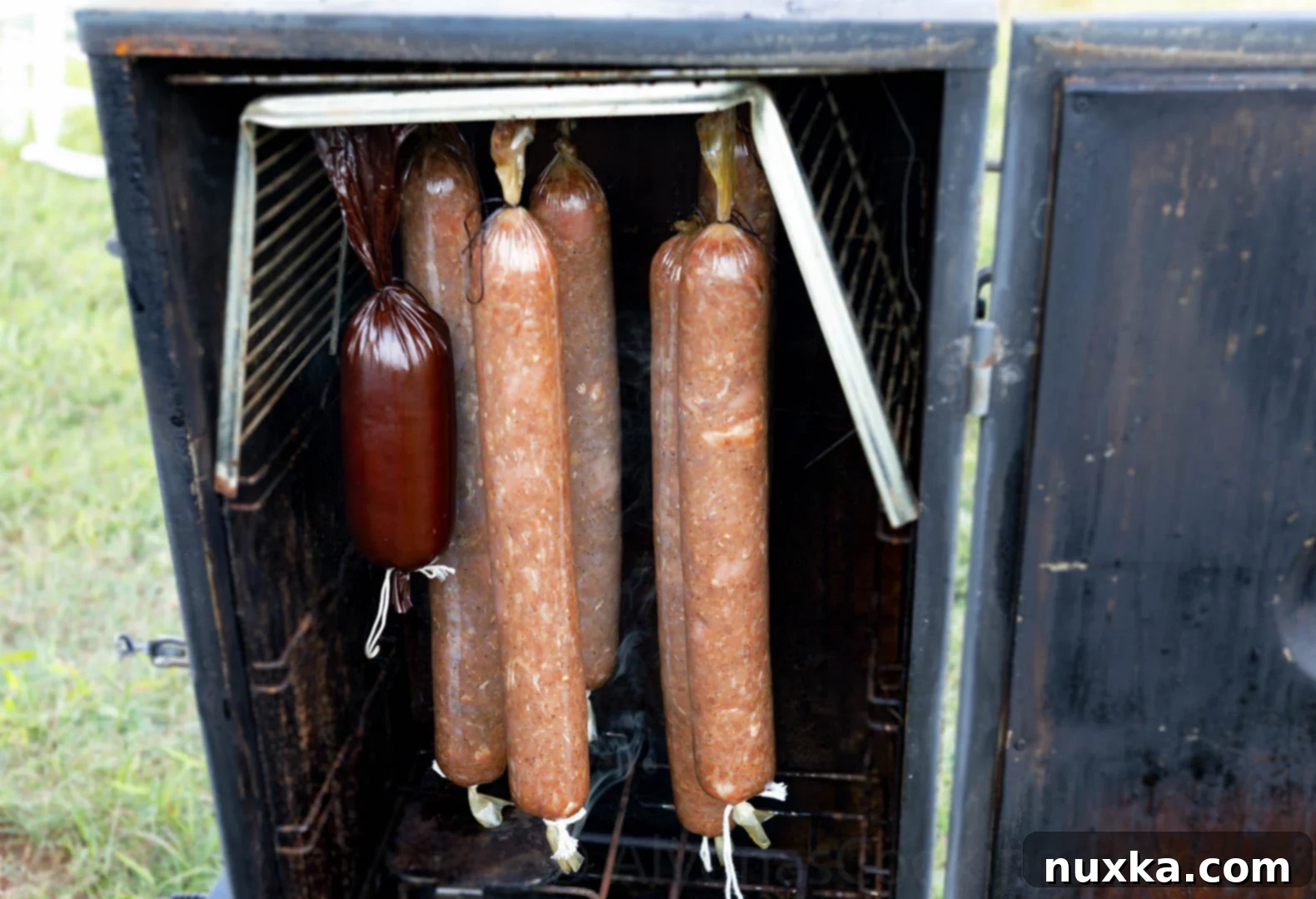 From Field to Table: Our Daily Provisions 34 image of homemade sausage making smoking in the smoker chamber