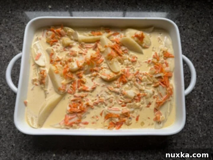 Cream-Infused Baked Potato Wedges 14 image of baked creamy potato wedges in heavy cream sauce emerging golden brown from the oven