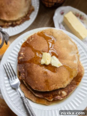 whole wheat sourdough pancakes served on a plate with butter and maple syrup