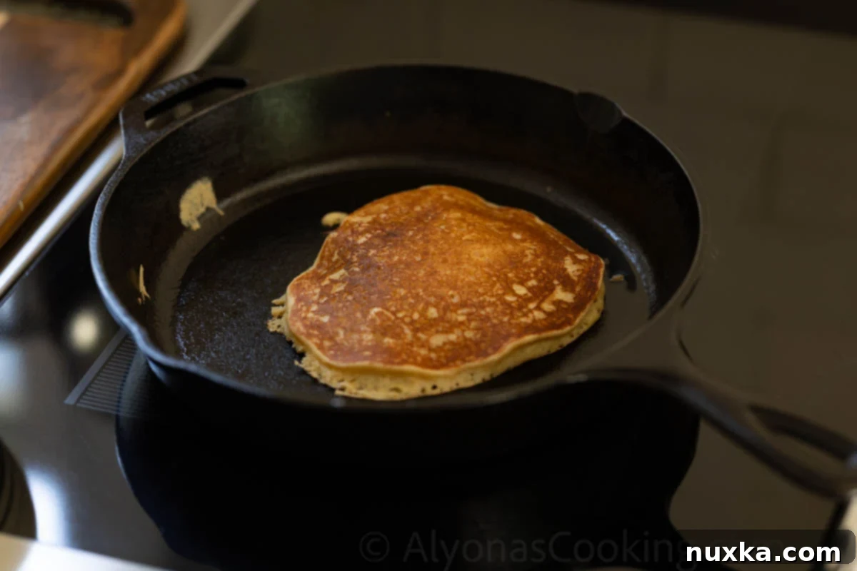 fluffy einkorn pancakes on a cast iron skillet 
