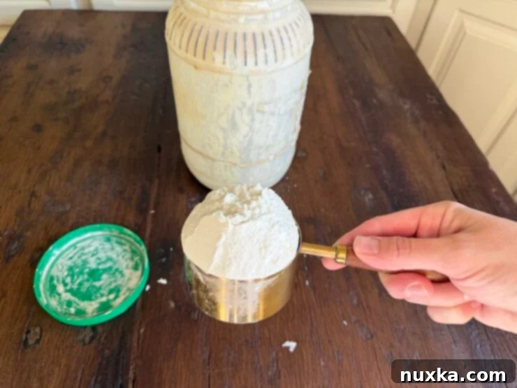 Effortless Everyday Sourdough 5 Measuring out the reserved sourdough starter, typically 1-2 cups