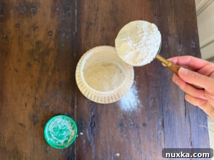 Effortless Everyday Sourdough 6 Adding two heaping cups of unbleached flour to the sourdough starter