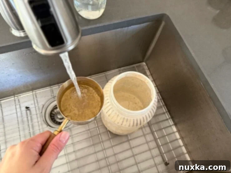 Effortless Everyday Sourdough 7 Adding two to three cups of warm water to the flour and starter mixture