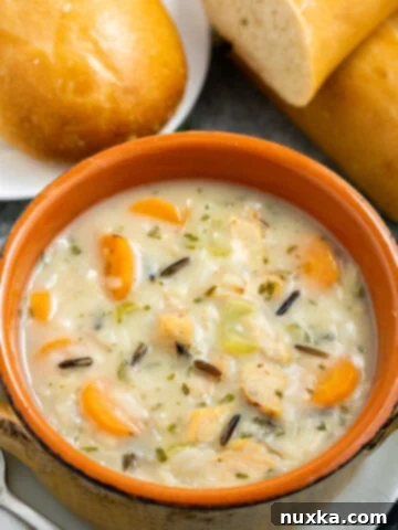 Bowl of creamy chicken and wild rice soup, garnished with fresh parsley