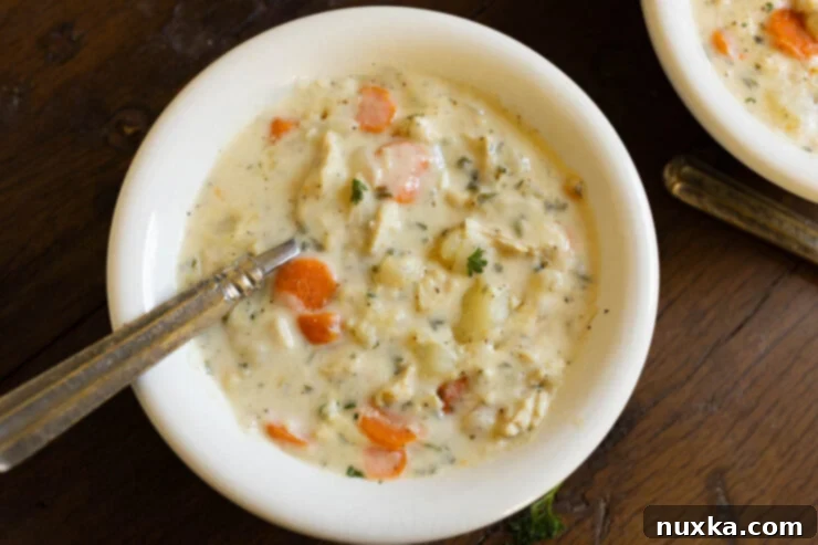 A bowl of homemade chicken chowder with a vintage spoon, ready to be enjoyed.