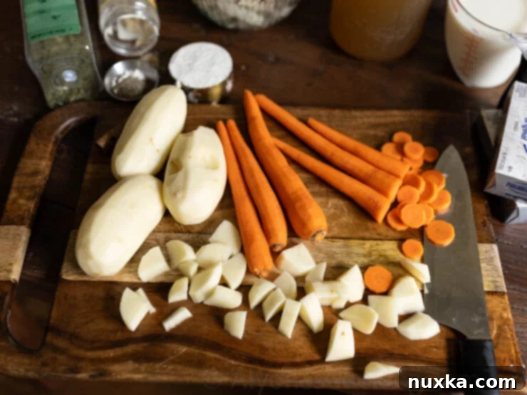 Chopping carrots and potatoes on a cutting board, prepared for chicken chowder.