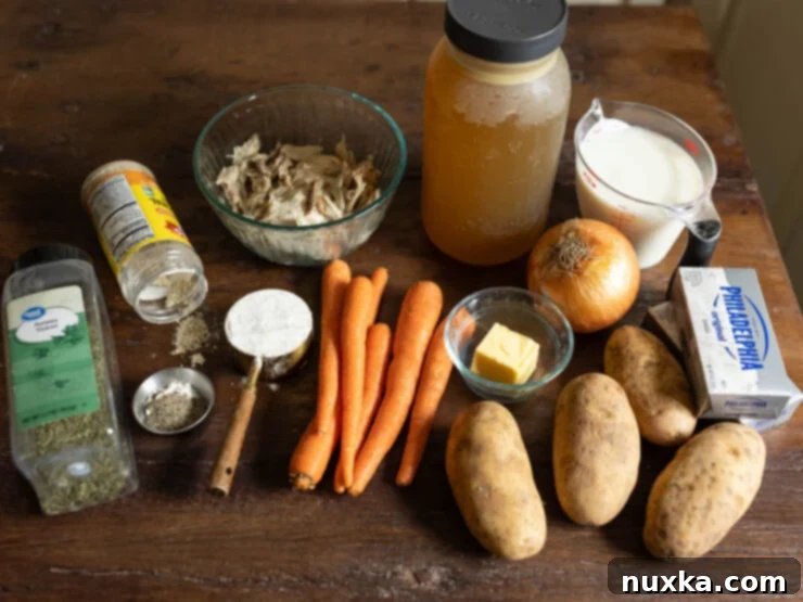 Close-up of fresh ingredients for chicken chowder: carrots, potatoes, onion, and chicken.