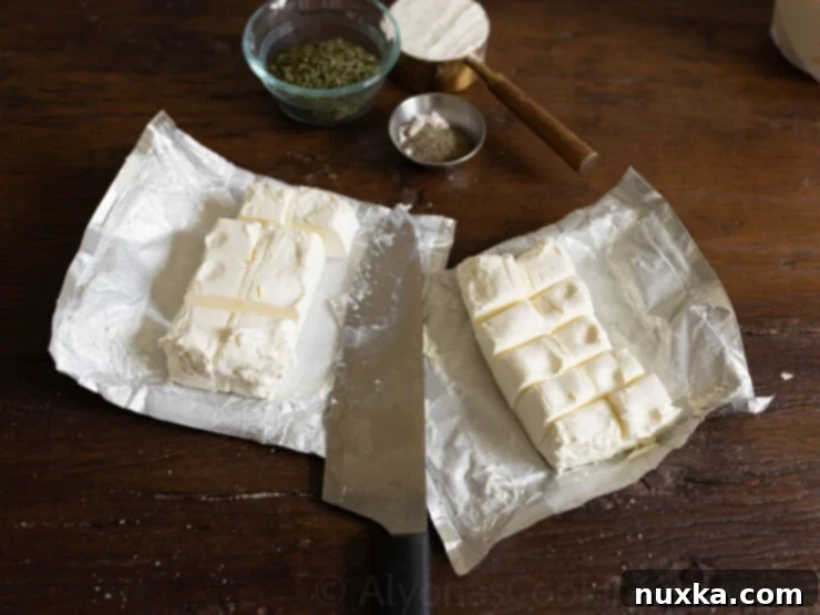 Adding cubed cream cheese to a simmering pot of chicken chowder for ultimate creaminess.