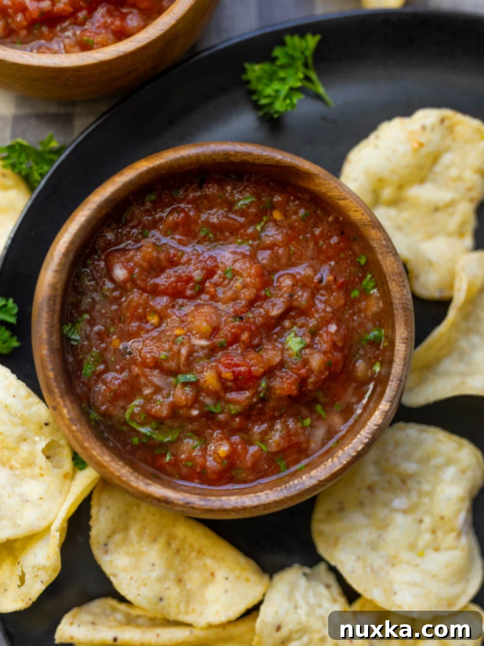 image of homemade salsa made from canned diced tomatoes served on a black plate with tortilla chips