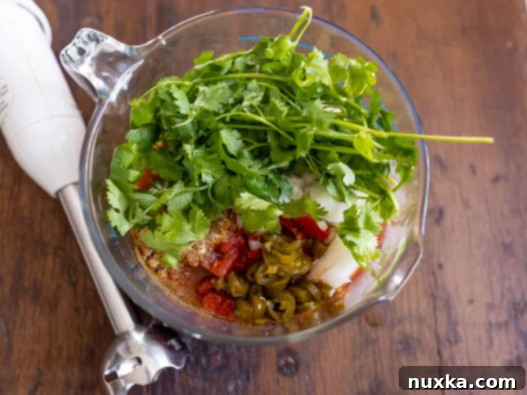 image of salsa ingredients in a large measuring cup ready to blended