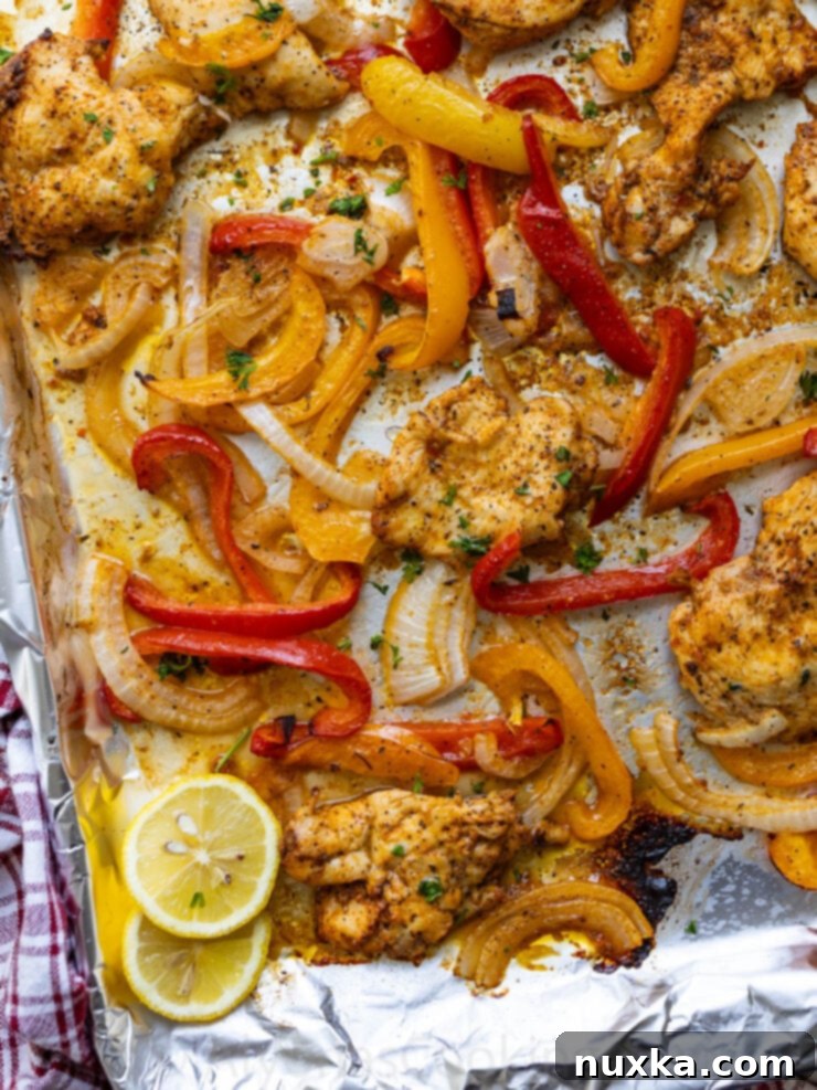 Close-up of Italian chicken and bell peppers on a sheet pan.